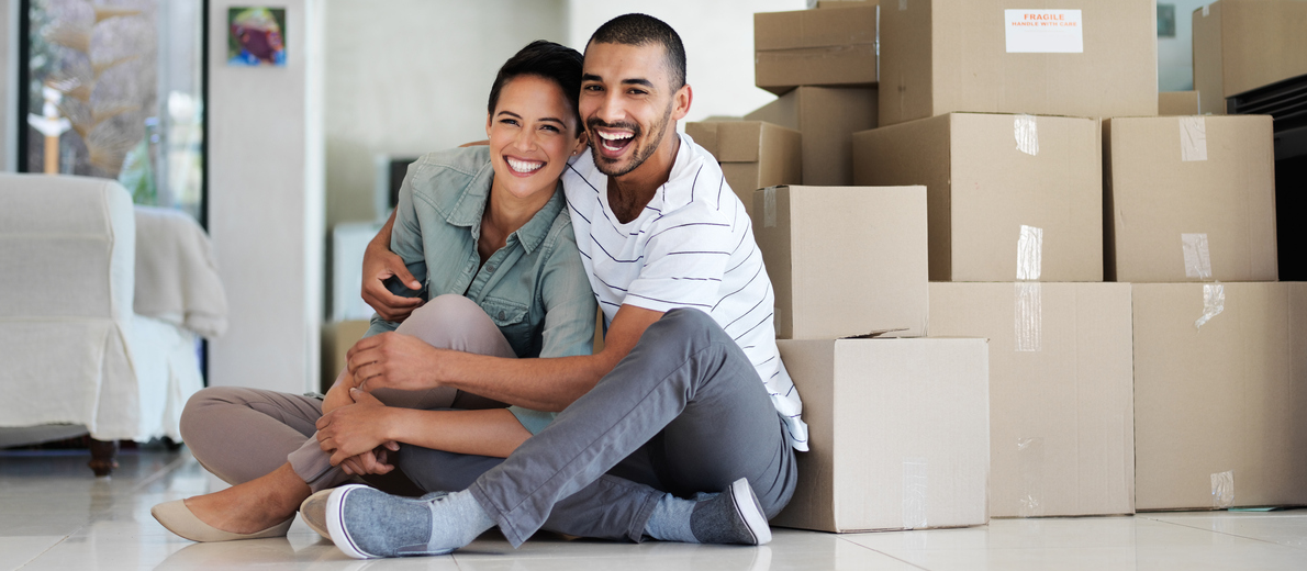 couple sitting in house with boxes to unpack